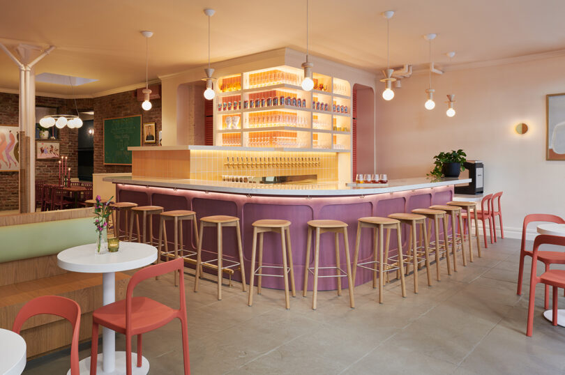 A restaurant with stools and a lavender bar.