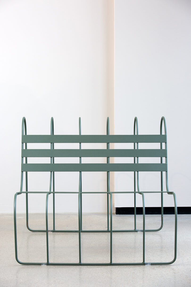 A minimalist metal bench situated in a bright room.