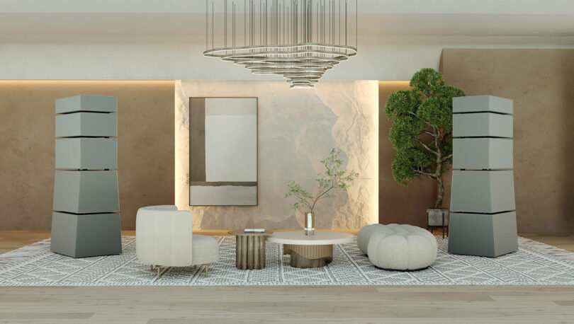 Modern living room interior with stylish furniture, elegant decor, and wireless Goldmund Theia speakers.