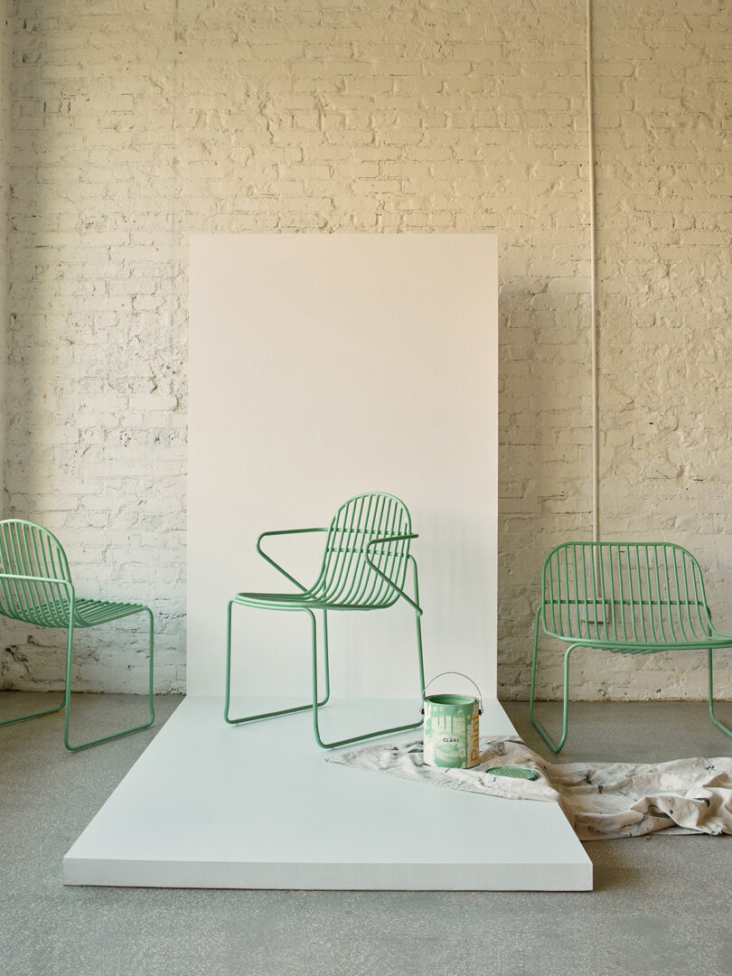 Três cadeiras contemporâneas verdes claras com design minimalista em uma sala iluminada.