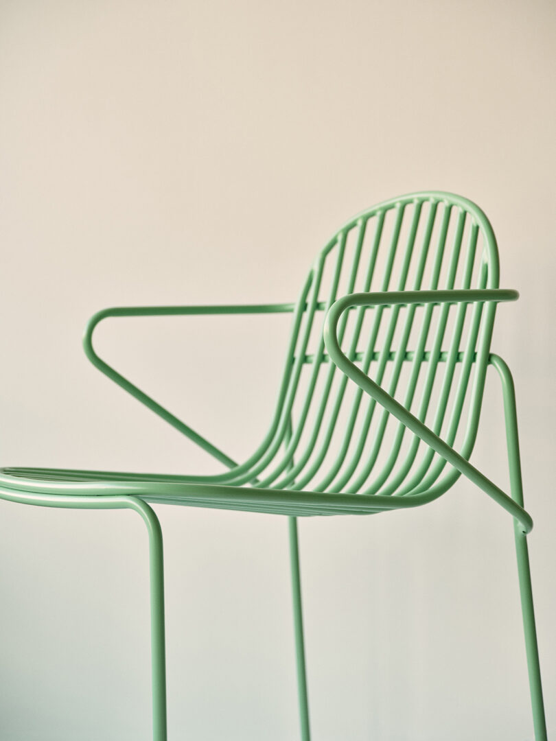 Cadeira contemporânea verde clara com design minimalista em uma sala iluminada.