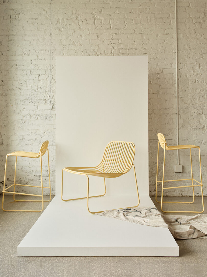 Três cadeiras contemporâneas em amarelo claro com design minimalista em uma sala iluminada.