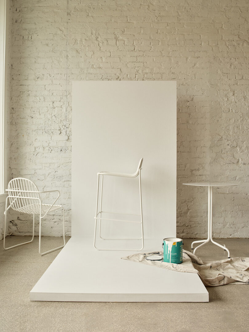 Três cadeiras brancas contemporâneas com design minimalista em uma sala iluminada.