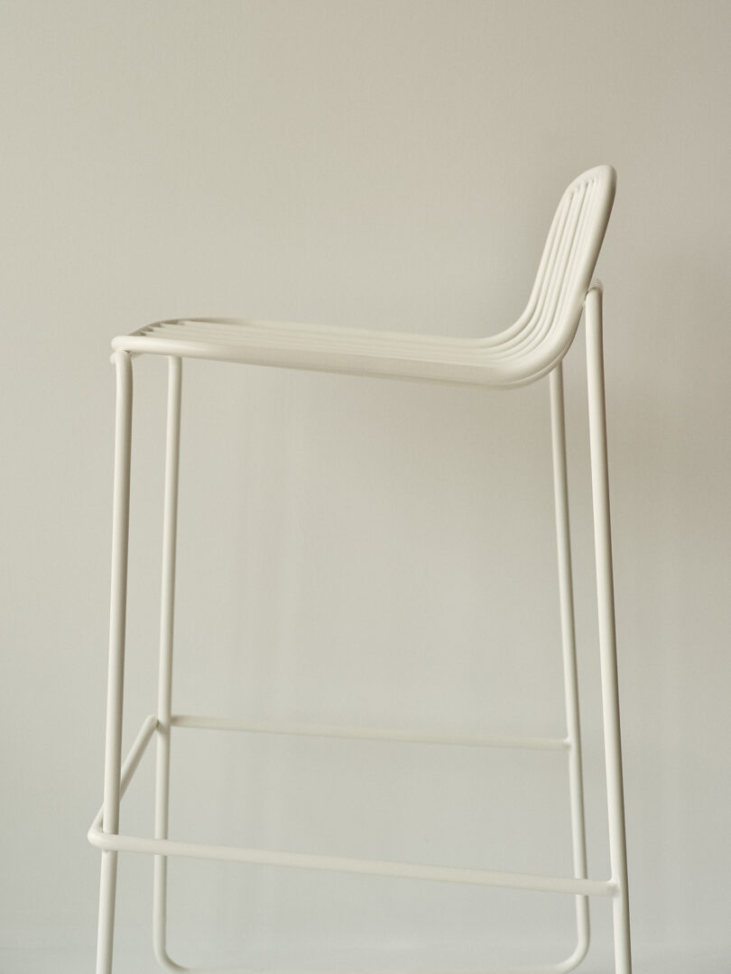 Cadeira contemporânea branca com design minimalista em uma sala iluminada.