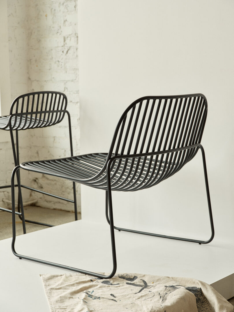 Duas cadeiras pretas contemporâneas com design minimalista em uma sala iluminada.