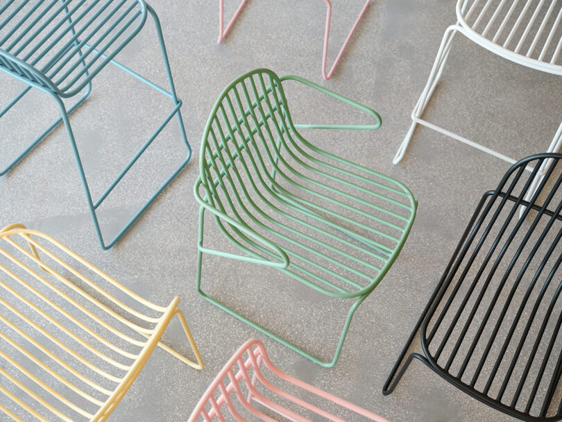 Várias cadeiras contemporâneas coloridas com design minimalista em uma sala iluminada.