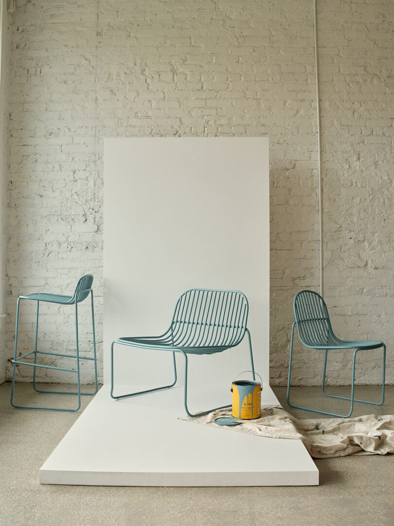 Três cadeiras contemporâneas em azul claro com design minimalista em uma sala iluminada.