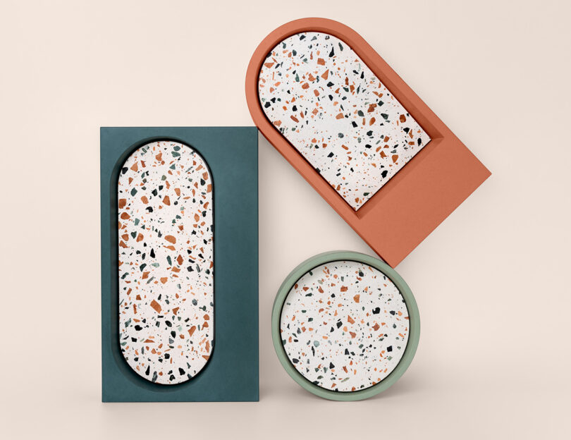 A group of three colorful rectangular, circular and semicircular concrete sinks with terrazzo inset.