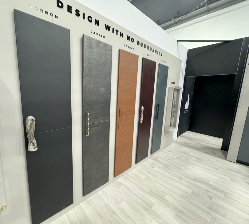 A row of leather wrapped refrigerator doors displayed on a wall at the KBIS event, each door has a unique handle attached to its left side.