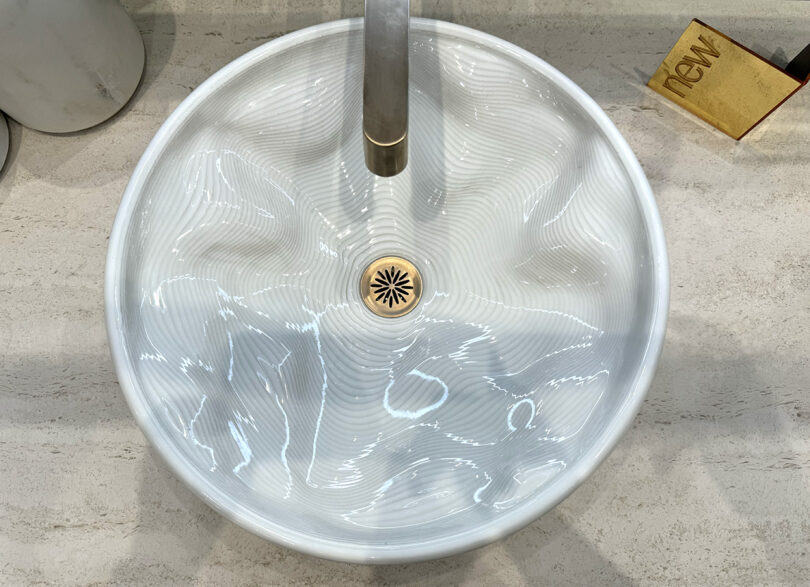 An overhead of a white sink in a bathroom with a faucet, featured at KBIS.