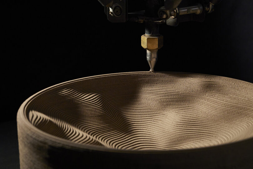 A 3D printing machine creating a circular bathroom sink layer by layer