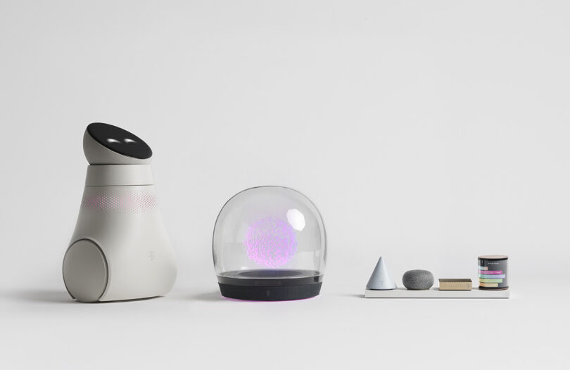 A mobile smart robot with circular display "face", holographic domed home hub, and 4-piece modular router platform.