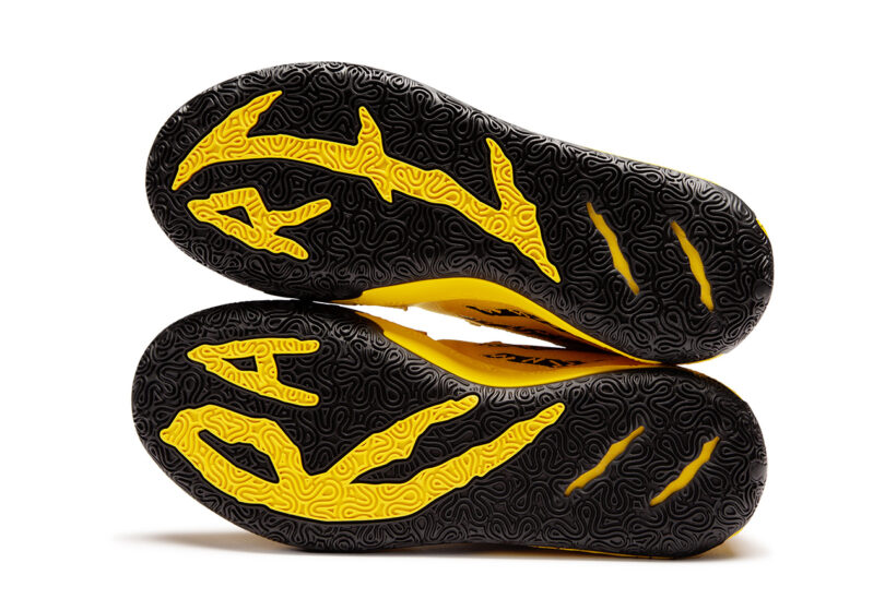 A pair of PUMA x Porsche Basketball Collection sneakers with yellow and black ripped design sole