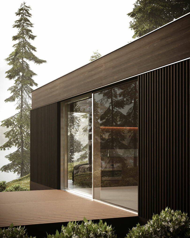 Modern wooden cabin with large glass windows surrounded by the Swedish landscape.