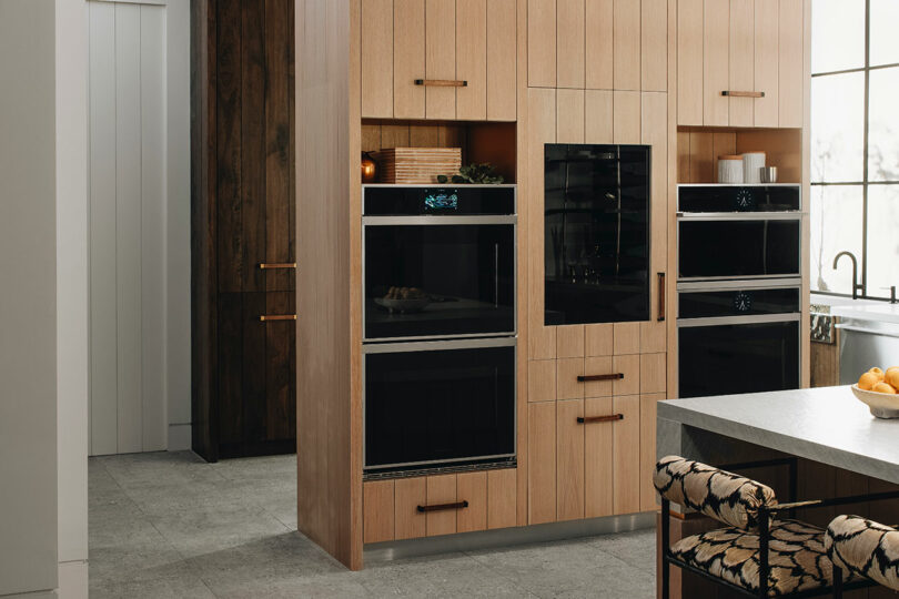 Modern kitchen interior with wooden cabinetry and built-in appliances.
