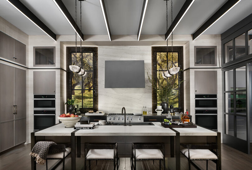 Modern kitchen with stainless steel appliances, a central island, and pendant lights.