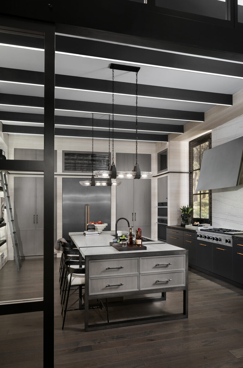 Modern kitchen with dark wood floors, stainless steel appliances, pendant lighting.