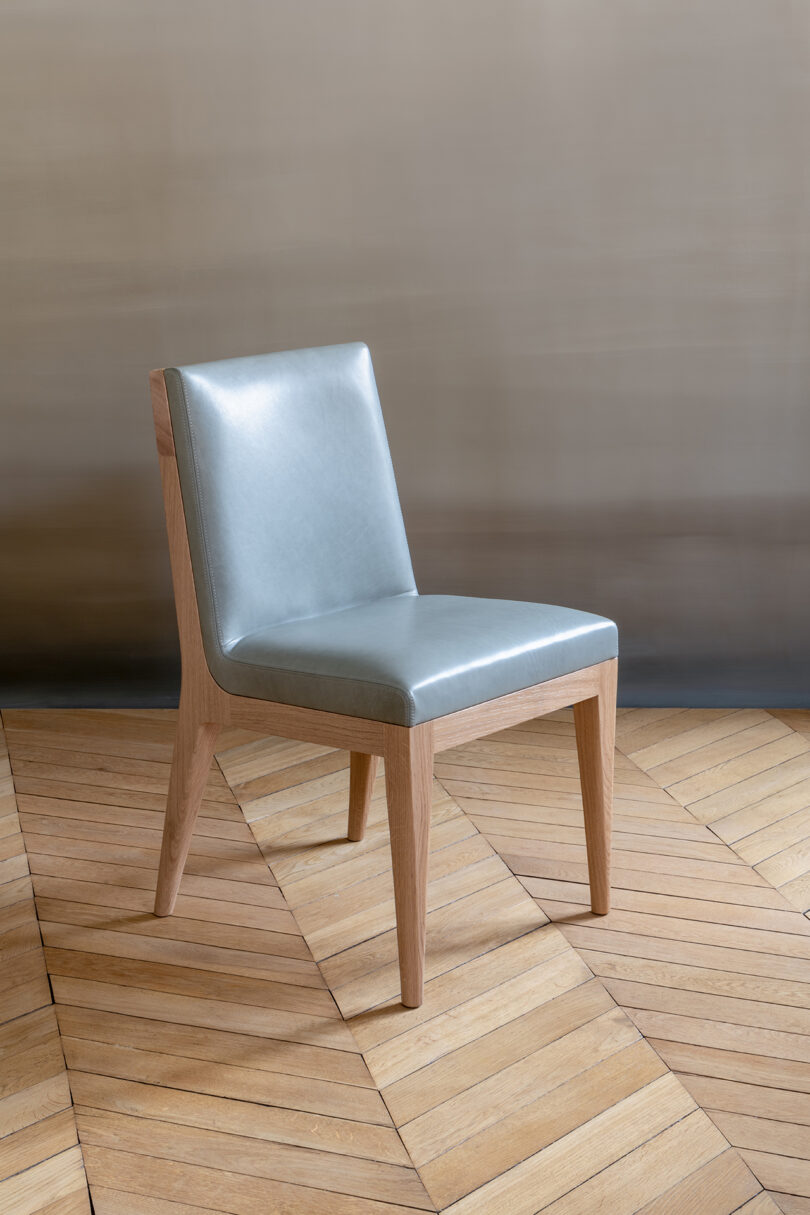 A chair with a leather seat on a wooden floor.