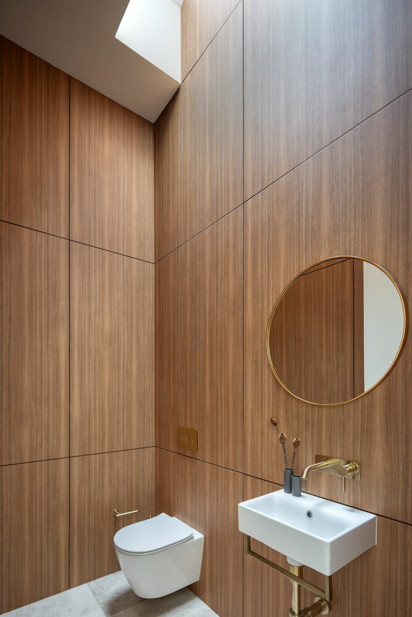 A bathroom with wooden walls and a sink.