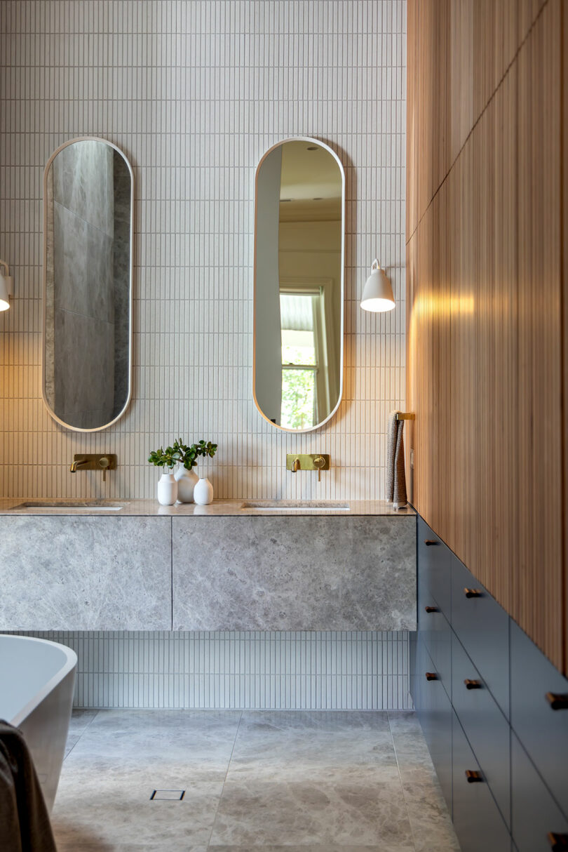 A modern bathroom with two sinks and mirrors.