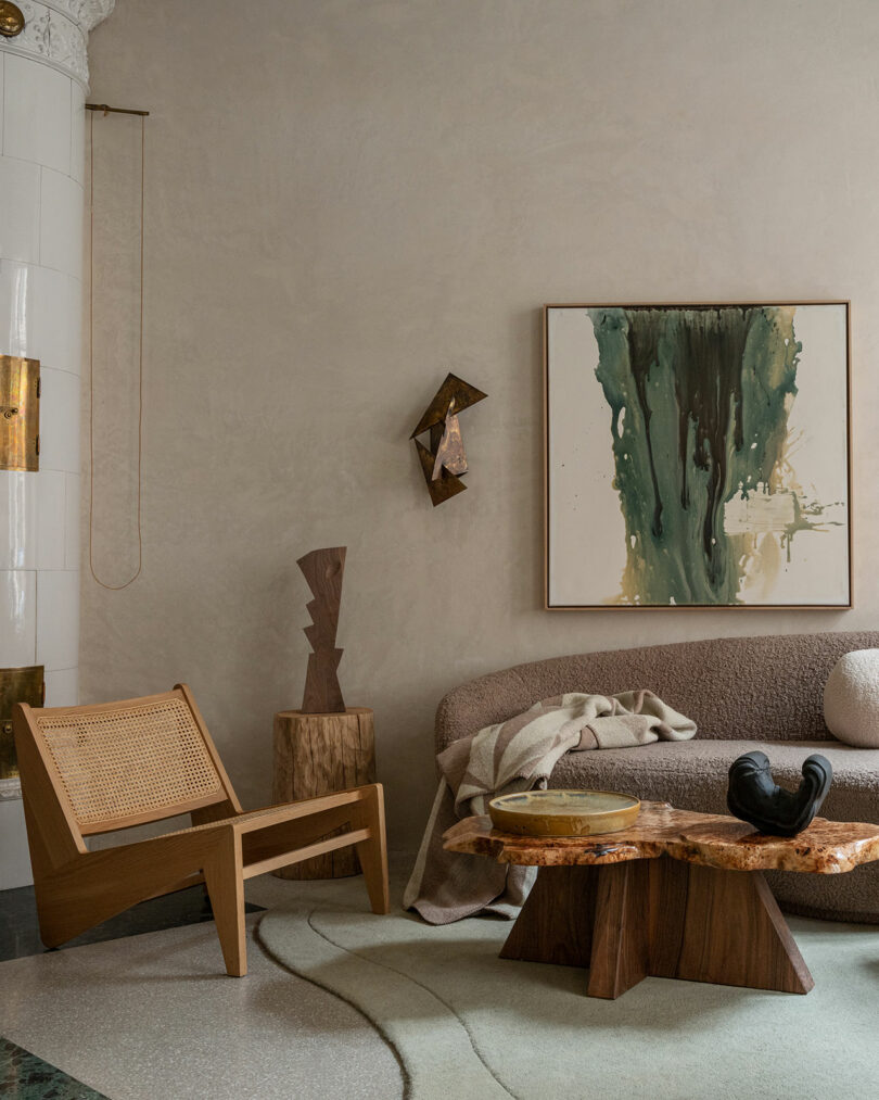 A lounge space with various forms of seating, wall art, a coffee table, and sconces.