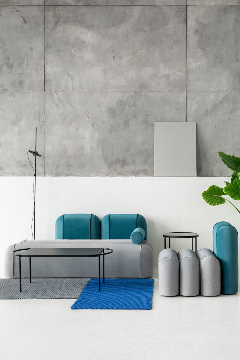 Modern living space with a grey and blue sofa, coordinating chair, coffee table, and side table.