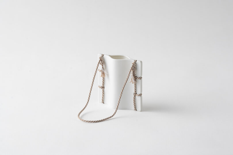 ceramic vase with thread detail on white table