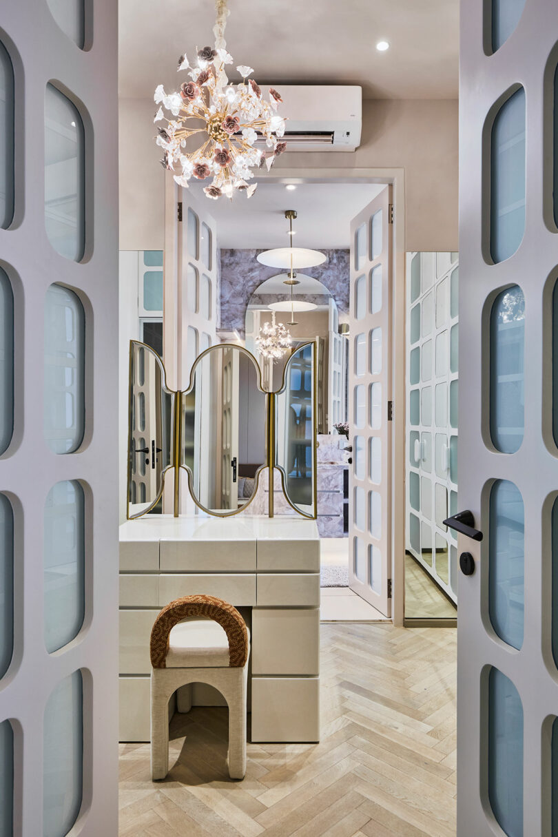 Modern vanity area with decorative mirrors, a stylish stool, and elegant lighting fixtures in a chic closet space.