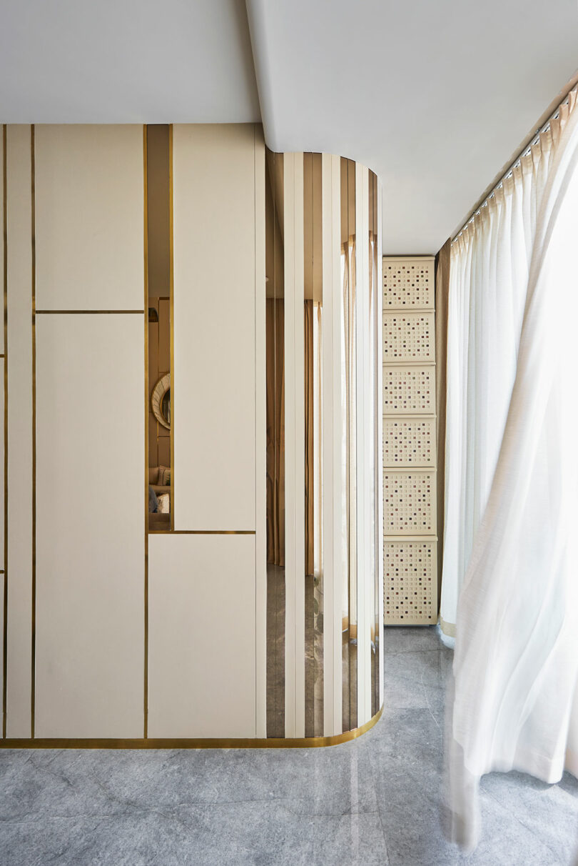 گوشه داخلی شیک با دیوار منحنی طلایی و پرده های شفاف.