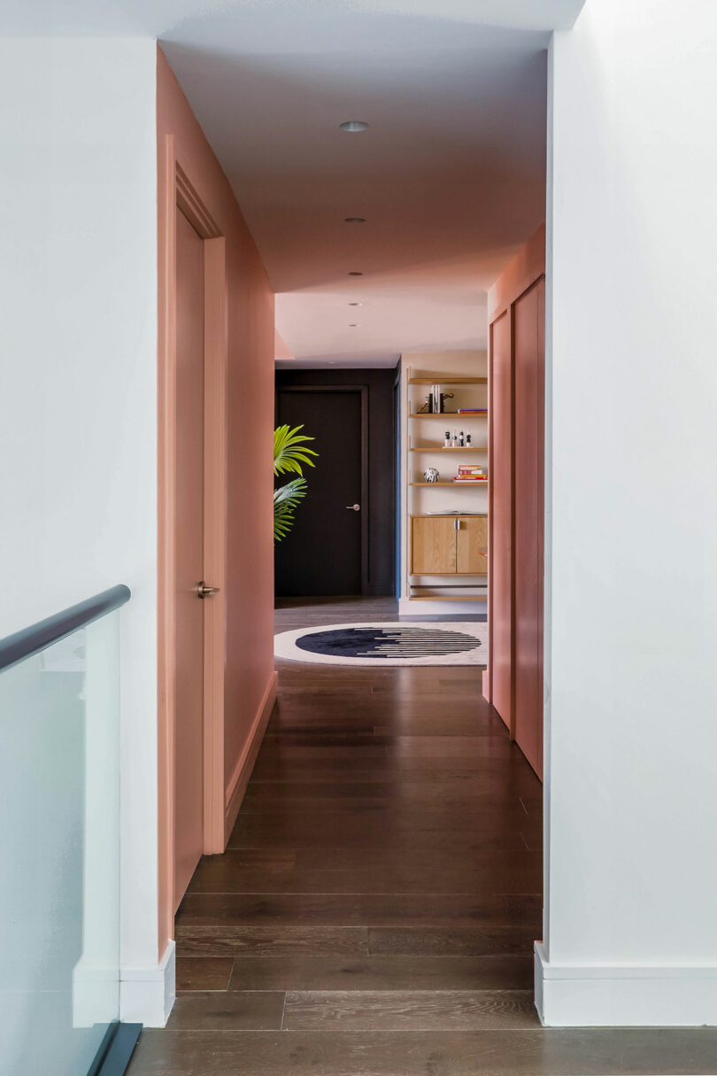 A pink hallway leading to an open room.