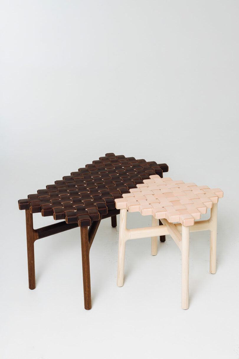 Two modern stools with interlocking wooden and leather designs, one dark brown and one light beige, against a white background.