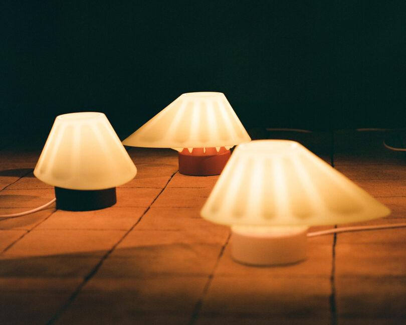 Three lamps on a tile floor.