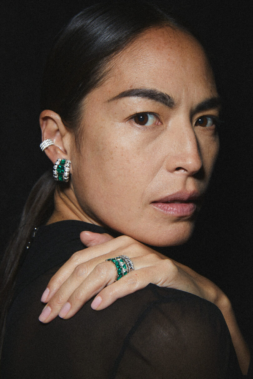 woman wearing emerald ring and earrings