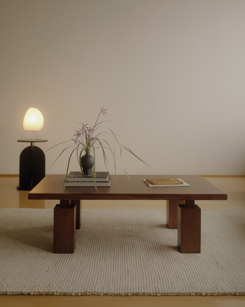 a coffee table on a rug next to a lamp