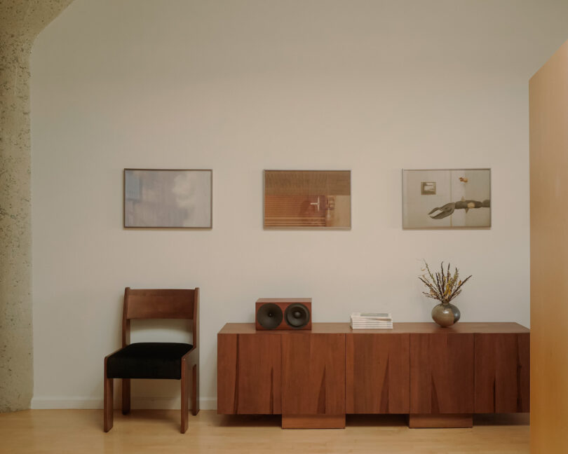 three artworks above a console and a chair
