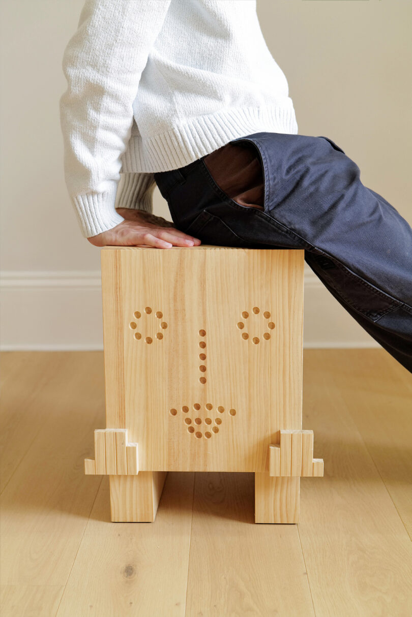 person sitting on stool with face on it