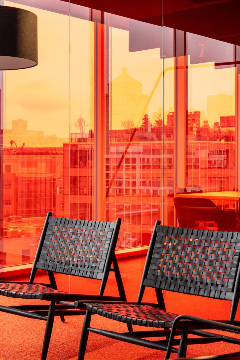 black chairs in front of orange glass wall