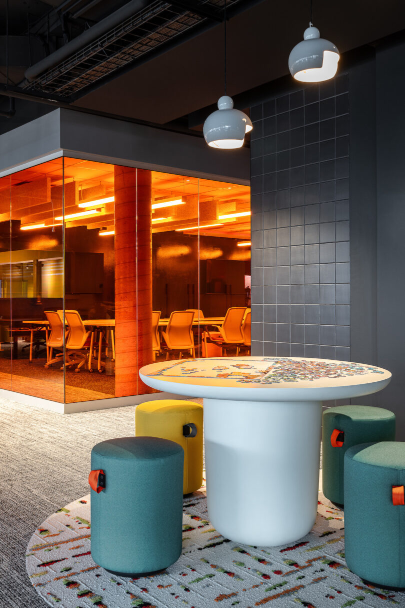An office with a round table and colorful stools.