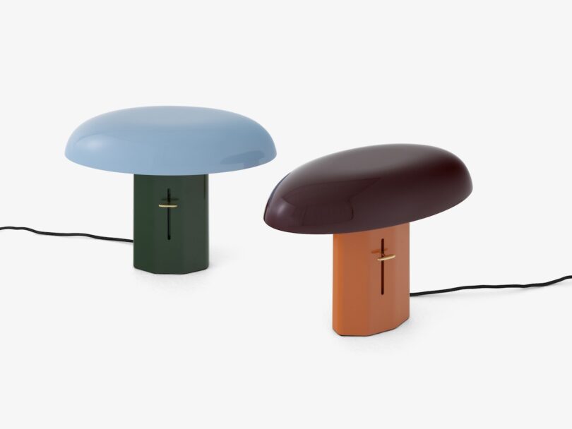 Two modern table lamps with cables, one with a blue top and green base, the other with a brown top and orange base.