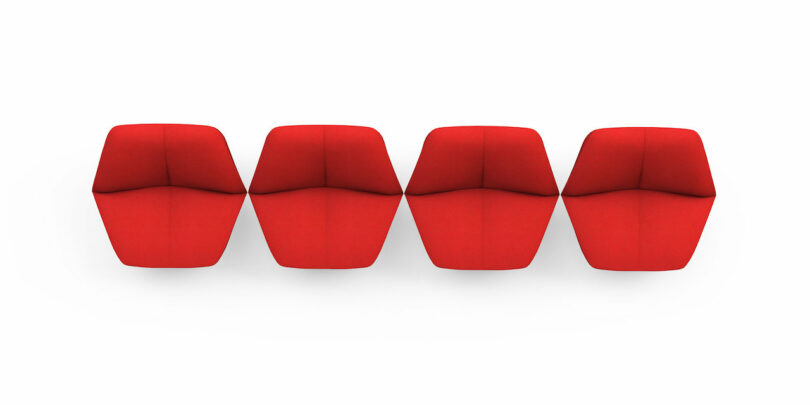 four red chairs shaped like lips arranged in a line