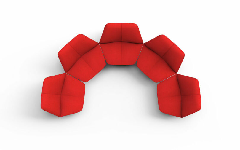 five red chairs shaped like lips arranged in a half circle