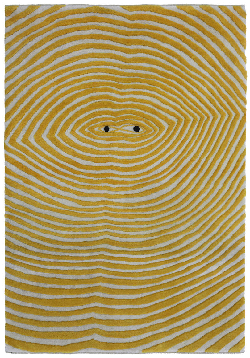 rippled yellow and white rug with eyes in the middle