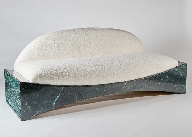 Modern sofa with white upholstery and an arch-shaped green marble base.