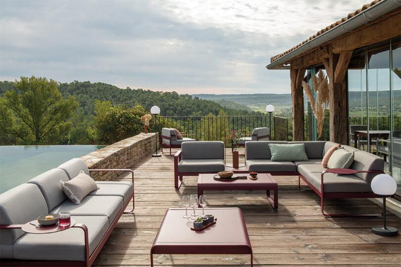 Outdoor terrace with modern lounge furniture overlooking a scenic view.