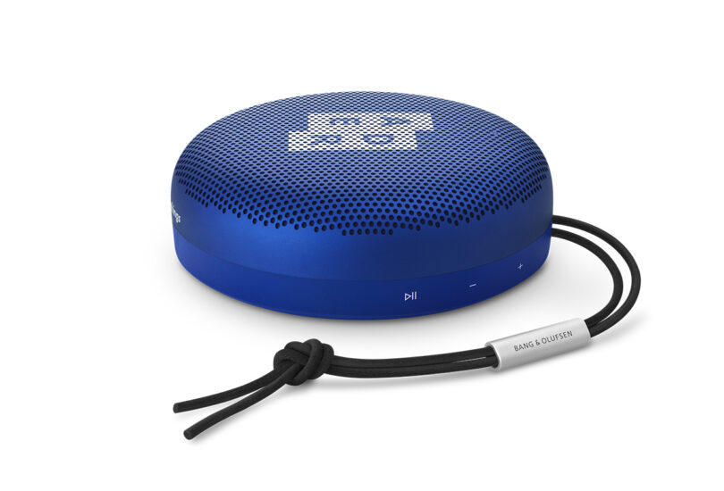Blue portable Bluetooth speaker with a looped wrist strap, branded by Bang & Olufsen's Beosound A1 ADER ERROR Edition.