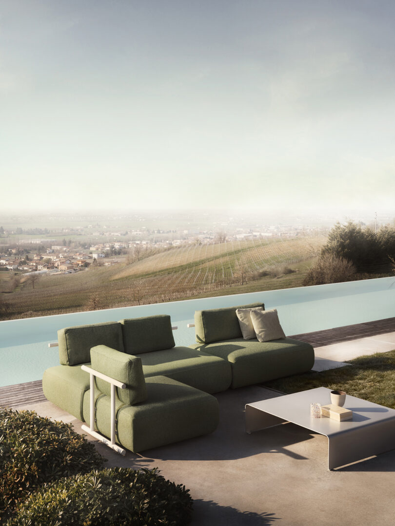 Modern outdoor furniture on a terrace overlooking a landscape.