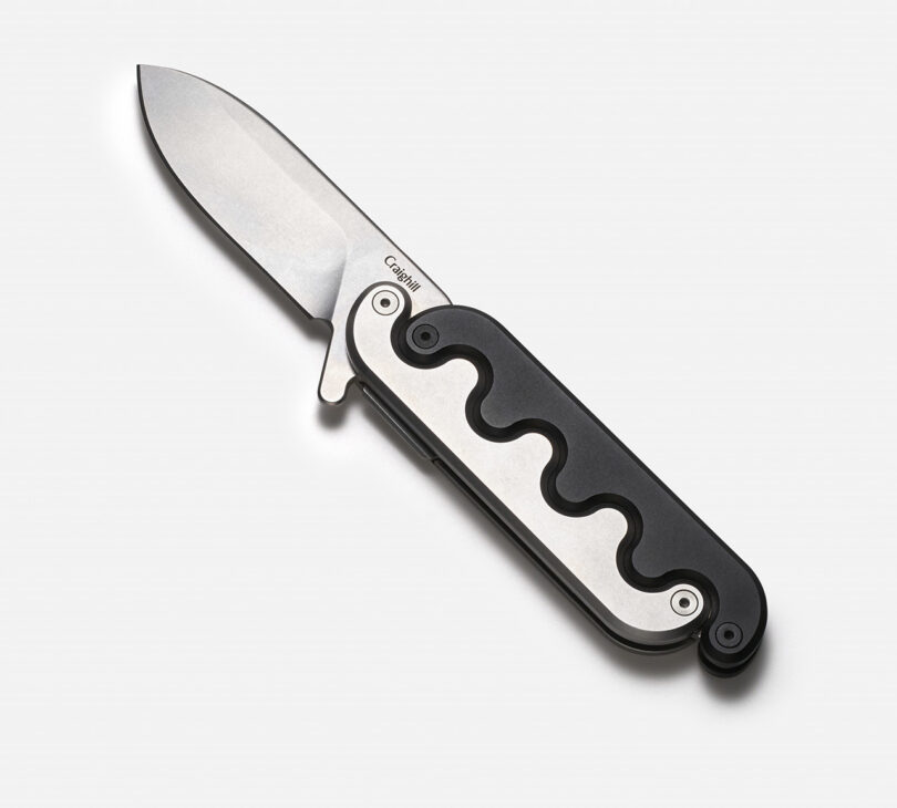 Sidewinder pocket knife with a black and silver interlocking handle open on a white background.