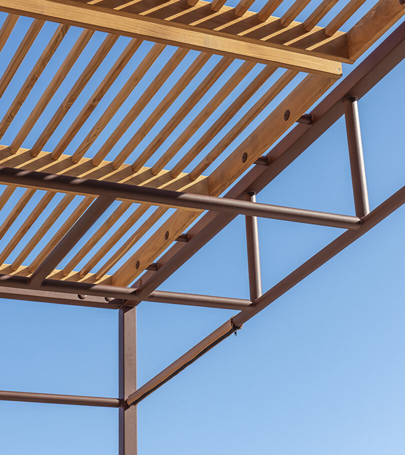 Underside view of OUT-FIT outdoor gym's metal frame and teak wood slats.