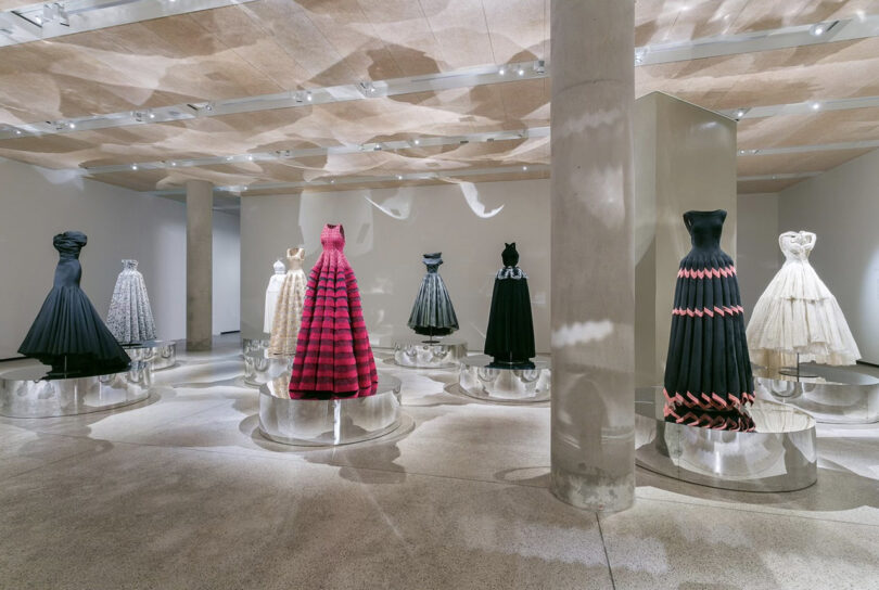 Elegant dresses on display in a museum gallery.