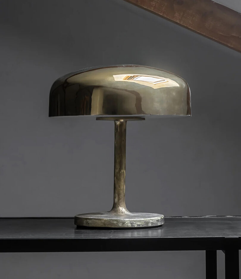 brass table lamp sitting on a black surface.